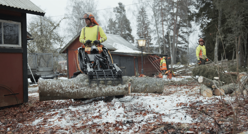 Trädfällare från Djupeskog Trädfällning forslar bort virke från en plats för trädfällning hos en skogsägare.